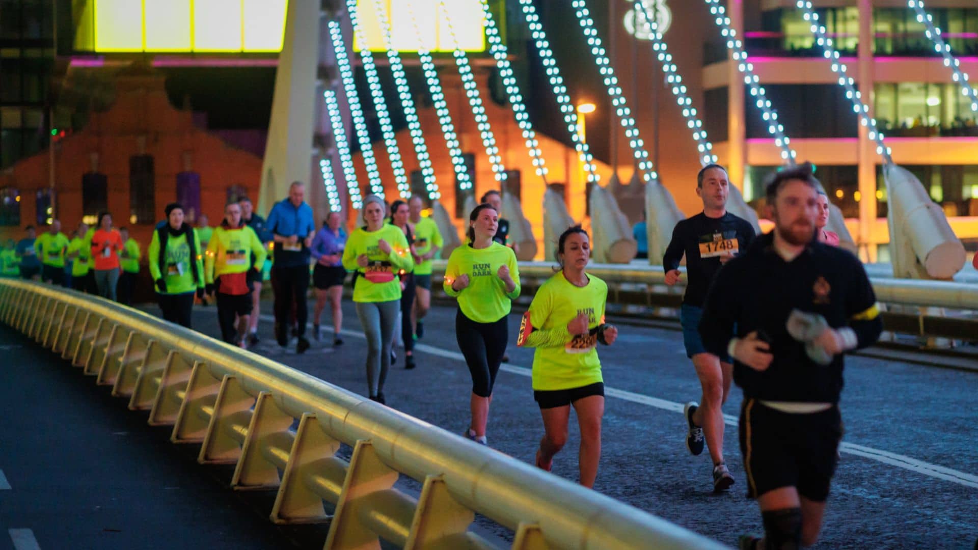 Runners in yellow tops on bridge