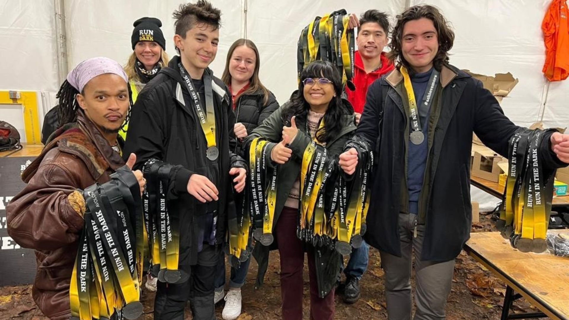 Volunteers with bunches of Run in the Dark medals